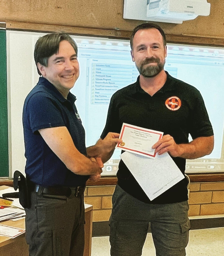 Photo of Patrick shaking hands with Dr. Robert Koester after completing the Lost Person Behavior Train the Trainer course.