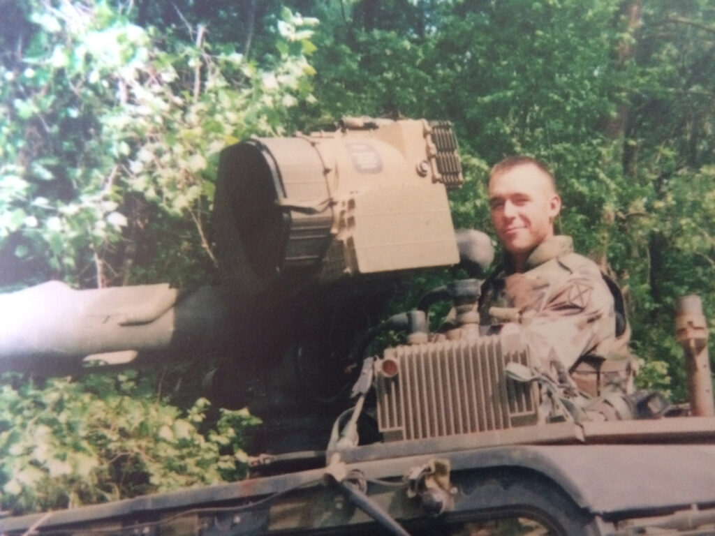 Instructor Patrick Diedrich in the turret of a military vehicle.