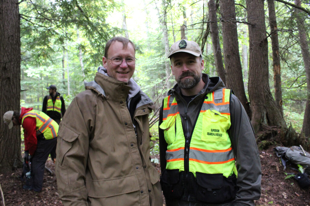 Photo of Larry Roberts with Patrick Diedrich standing in the Lake Linden Forest during SAR Survival training.